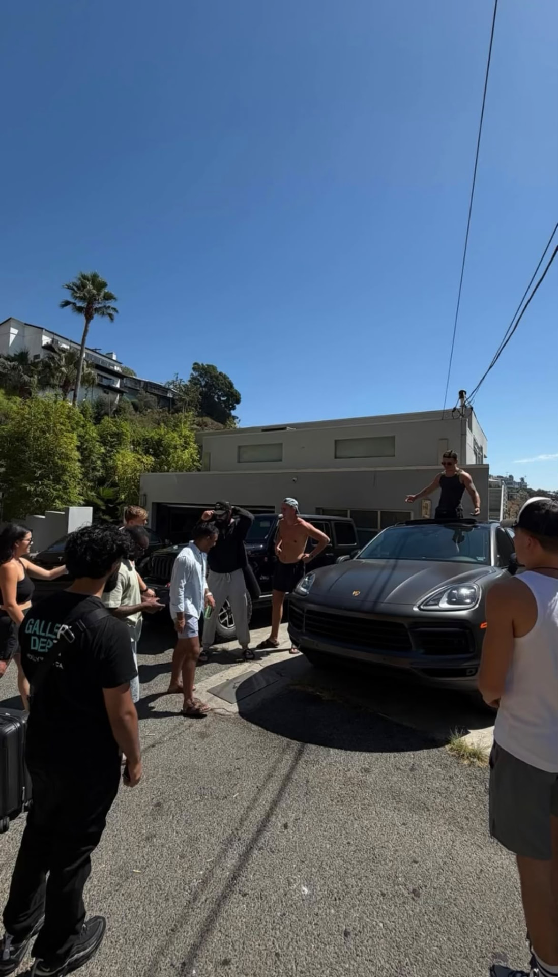 The team relaxing by the cars on a team trip